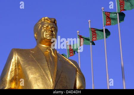 Bandiere turkmeno in onda il vento dietro uno dei tanti golden statue dell ex Presidente turkmeno per la vita, Saparmurat Niyazov nel capitale Aşgabat, Turkmenistan, 25 febbraio 2008. Niyazov morto nel dicembre 2006, aveva il suo popolo adorarlo come Türkmenbaşy il significato di "Padre del Turkmeni'. Foto: Tim Brakemeier Foto Stock
