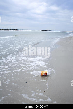 (Dpa) file il file immagine datata settembre 2007 mostra una bottiglia di plastica preso avanti e indietro dalle onde sulla spiaggia di Wustrow, Germania. Foto: Wolfram Steinberg Foto Stock