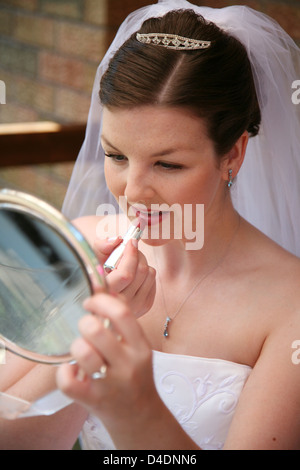 Una sposa si appresta, mettendo il rossetto Foto Stock