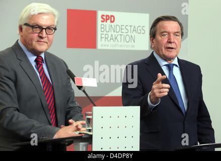 L'ex cancelliere tedesco Gerhard Schroeder (R) e SPD gruppo parlamentare presidente Frank-Walter Steinmeier parla durante una conferenza stampa dopo la riunione del sociale parte democratica gruppo parlamentare del Reichstag a Berlino, Germania, 12 marzo 2013. Foto: WOLFGANG KUMM Foto Stock