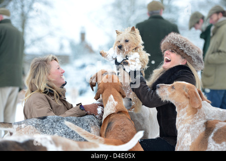 Due signore sollevare i loro Norfolk Terrier cane lontano da curiosi hounds nel corso di una riunione del Beaufort Hunt in Badminton Park J Foto Stock