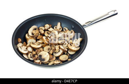 Una grande quantità di funghi tagliati a fettine per la cottura in olio di oliva in una padella grande su uno sfondo bianco. Foto Stock