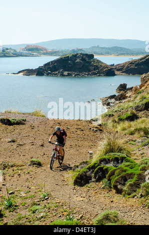Mountain biker sulla Cami de Cavalls sentiero costiero a Minorca nelle Isole Baleari, Spagna Foto Stock