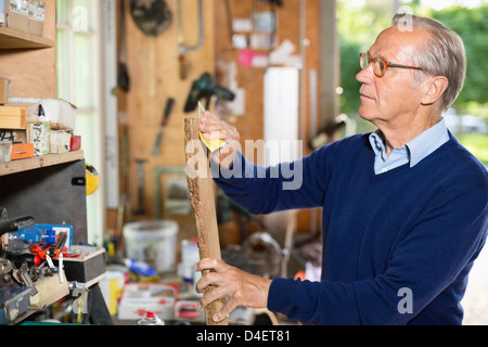L'uomo la levigatura del legno in garage Foto Stock