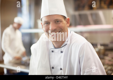 Lo Chef sorridente nel ristorante cucina Foto Stock