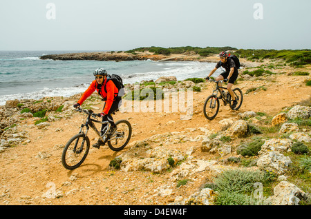Gli amanti della mountain bike sul Cami de Cavalls sentiero costiero a Minorca nelle Isole Baleari, Spagna Foto Stock