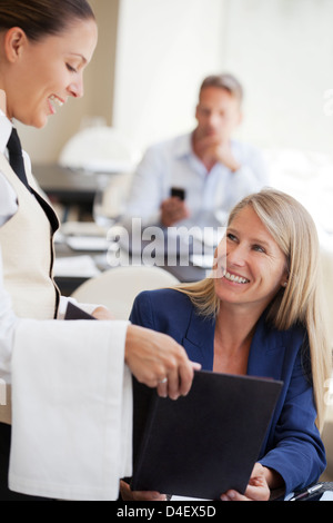 Imprenditrice di ordinare in ristorante Foto Stock