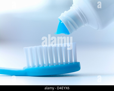 Close up di dentifricio schiacciamento sulla spazzolino da denti Foto Stock