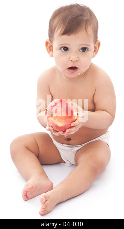 Funny baby con apple seduto sul pavimento. Isolato su uno sfondo bianco. Foto Stock