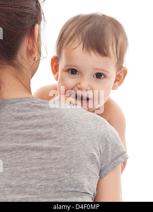 Bambino su mamma mani mantenendo il dito in bocca Foto Stock