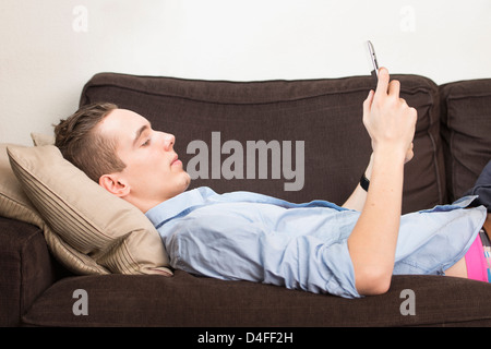 Momento di stile di vita con una rilassata giovani maschi adulti in possesso di una tavoletta digitale dispositivo nelle sue mani. Foto Stock