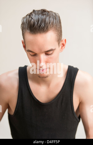 Considerato giovane adulto uomo che guarda in basso con espressione pensieroso Foto Stock