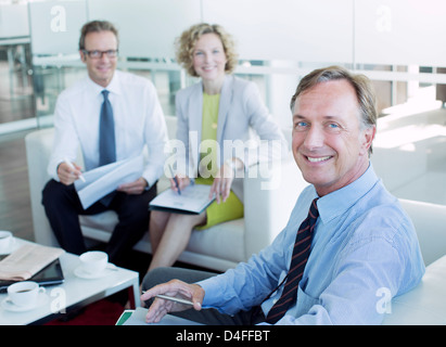 La gente di affari sorridente in ufficio lobby Foto Stock