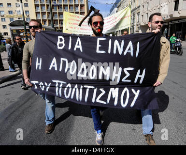 Atene, Grecia. 13 marzo 2013. Un uomo detiene un banner con un'ascia nella sua testa durante una manifestazione di protesta da parte dei dipendenti del Ministero della Cultura in Atene, Grecia su 13.03.2013. A causa consecutivi di 24 ore di sciopero da parte dei dipendenti, stato musei e siti archeologici dovrebbe rimanere chiusa fino al 19.03.2013. I dipendenti sono in battuta contro la prevista ristrutturazione dell'Amministrazione culturale e richiedere un apposito ministero della Cultura, come è stato in precedenza. Credito: Arte di Focus / Alamy Live News Foto Stock