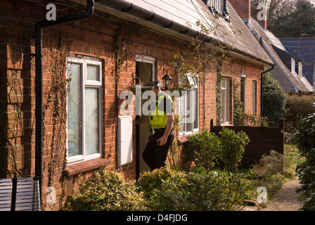 Funzionario di polizia entrando in casa di sospetto arrestato per le minacce di uccidere, Selborne, Hampshire, Regno Unito. Foto Stock