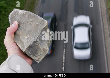 Foto simbolico - un uomo sta per gettare un sasso su una macchina che passa al di sotto di un incrocio autostradale vicino a Osterode, Germania, 12 giugno 2008. Ulteriori e più gravi incidenti causati da ignoti che lanciano pietre da incroci autostradali sono stati registrati negli ultimi anni. Foto: Frank può Foto Stock