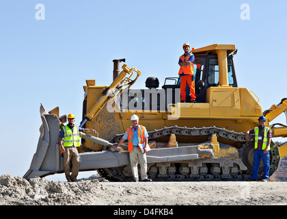 Lavoratori su bulldozer sorridente in cava Foto Stock