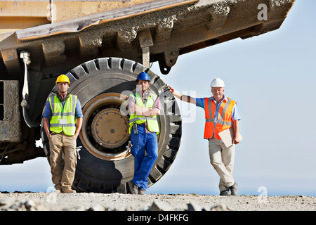 I lavoratori in piedi da macchinari in loco Foto Stock