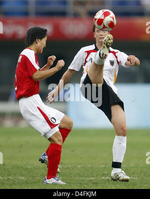 Renate Lingor (R) della Repubblica federale di Germania il sistema VIES con Ok Kim Sim della Corea del Nord (L) durante il calcio femminile Gruppo F turno preliminare corrispondono 13 tra Corea del Nord e la Germania durante i Giochi Olimpici di Pechino 2008 al Centro Olimpico Stadium di Tianjin, Cina, 12 agosto 2008. Foto: Marcus Brandt dpa ###dpa### Foto Stock