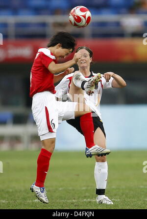 Renate Lingor (R) della Repubblica federale di Germania il sistema VIES con Ok Kim Sim della Corea del Nord (L) durante il calcio femminile Gruppo F turno preliminare corrispondono 13 tra Corea del Nord e la Germania durante i Giochi Olimpici di Pechino 2008 al Centro Olimpico Stadium di Tianjin, Cina, 12 agosto 2008. Foto: Marcus Brandt dpa ###dpa### Foto Stock