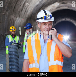 Imprenditore utilizzando un walkie-talkie nel tunnel Foto Stock