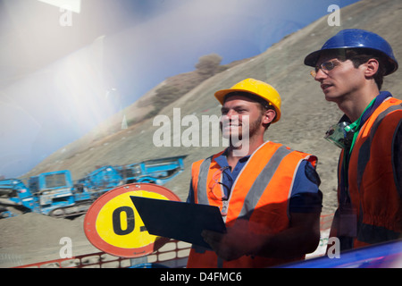 I lavoratori si riflette in una finestra sul sito Foto Stock