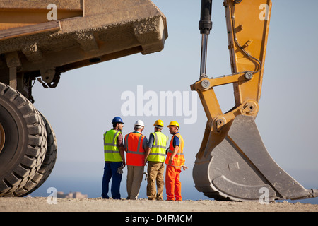 I lavoratori di parlare con macchinario in cava Foto Stock