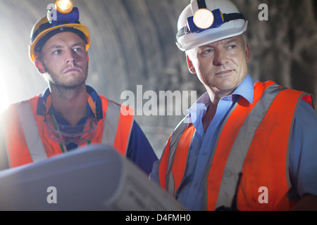 Lavoratore e imprenditore con blueprint nel tunnel Foto Stock