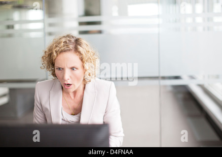 Sorpreso imprenditrice lavoro in ufficio Foto Stock