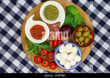 Ingredienti della cucina italiana su tavola di legno sulla tovaglia a scacchi Foto Stock