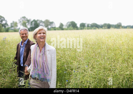 Paio di camminare in un campo di erba alta Foto Stock