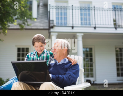 Uomo con notebook con il nipote all'aperto Foto Stock