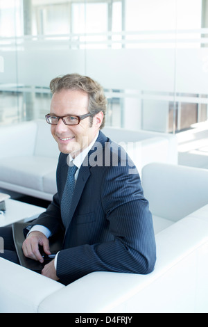 Imprenditore seduti sul divano nella lobby di office Foto Stock