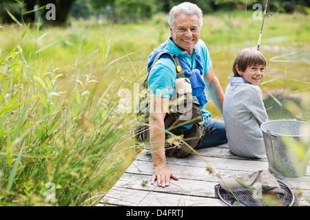 Uomo di pesca con il nipote sul dock in legno Foto Stock