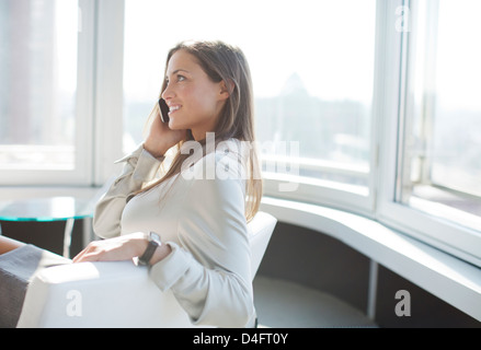 Imprenditrice parlando al telefono in ufficio Foto Stock