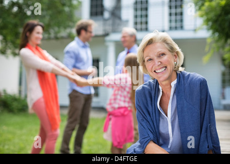 Donna sorridente seduti all'aperto Foto Stock