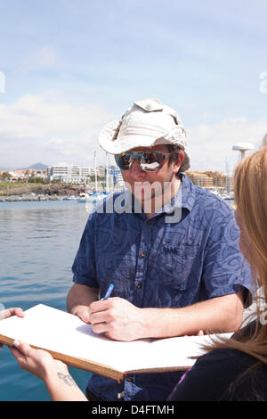 Tenerife. 13 marzo 2013. Jarle Andhoy segni la marina libro degli ospiti con il lancio ufficiale del più grande del mondo un messaggio in bottiglia ha avuto luogo a San Miguel Marina. La cerimonia di lancio condotta da Miss Tenerife Sur, Sady Chavez e polare norvegese explorer Jarle Andhoy ceremoniously chi ha rotto una bottiglia di soda da solista pop per l'occasione. Il bottlre sarà trainato fuori al mare e insieme alla deriva e chi lo trova come si arriva a terra saranno premiati con un premio dal solo soft drinks company. Credito: Phil Crean un / Alamy Live News Foto Stock