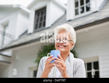 Donna con tazza di caffè all'aperto Foto Stock