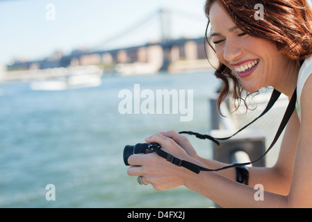 Donna di scattare una foto da ponte urbano Foto Stock