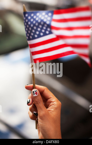 Donna con novità chiodi sventola bandiera americana Foto Stock