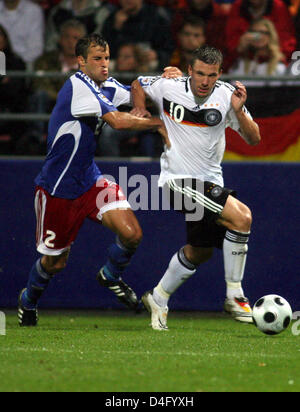 La Germania attaccante Lukas Podolski (R) combatte per la sfera contro il Liechtenstein il Marco Ritzberger durante la Coppa del Mondo il qualificatore Liechtenstein vs Germania a 'Rheinpark Stadium" di Vaduz, Liechtenstein, 06 settembre 2008. La Germania ha vinto la partita da 6-0. Foto: Bernd Weissbrod Foto Stock