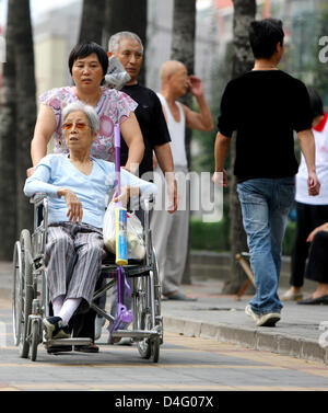 Una vecchia donna cinese viene spinto in una sedia a rotelle durante il XIII Giochi paralimpici di Pechino, Cina, 08 settembre 2008. Foto: Rolf Vennenbernd Foto Stock