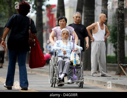 Una vecchia donna cinese viene spinto in una sedia a rotelle durante il XIII Giochi paralimpici di Pechino, Cina, 08 settembre 2008. Foto: Rolf Vennenbernd Foto Stock