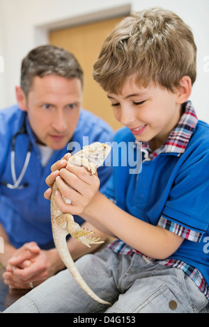 Veterinario e proprietario esaminando lizard in vet chirurgia dell Foto Stock