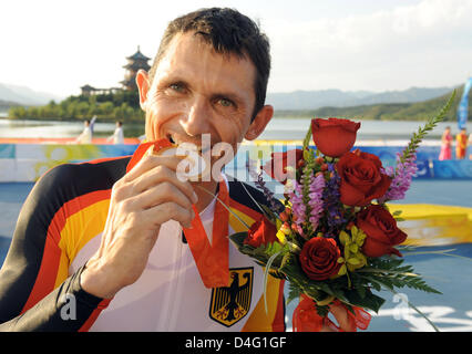 Michael Teuber dalla Germania morde la sua medaglia d oro dopo la sua vittoria nella cronometro individuale su strada al 2008 Giochi Paralimpici a Pechino in Cina, 12 settembre 2008. Foto: KAI-UWE WAERNER Foto Stock