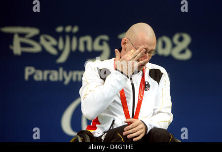 Nuotatore tedesco Thomas Grimm pulisce una lacrima durante la 100m a rana premiazione presso il Beijing 2008 Giochi Paralimpici a Pechino in Cina, 12 settembre 2008. Grimm era rifiutato la sua medaglia d oro dopo l'originale vincitore, Pedro messicano Rangel, è stato squalificato. Rangel ha protestato contro la decisione e i giudici hanno deciso a suo favore. Foto: ROLF VENNENBERND Foto Stock