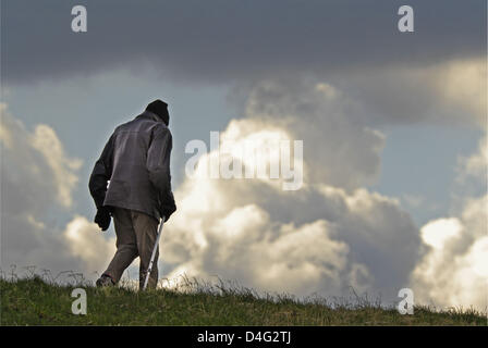 (Dpa file)- Di fronte a enormi Teste di Tuono, un uomo anziano prende una passeggiata sulla riva del fiume Elba a Luehe, Germania, 20 marzo 2008. Secondo uno studio del Deutsches Institut fuer Altersvorsorge (DIA, letteralmente: Tedesco institut di previdenza), quasi il 30 per cento delle famiglie tedesche sono minacciate dalla vecchiaia e povertà. In particolare l'ora 40 a 49-anno-vecchio sarà la mancanza di denaro in Foto Stock