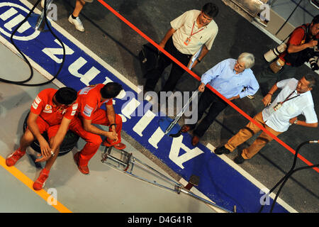 British F1 supremo Bernie Ecclestone (C) le chat con i meccanici della scuderia Ferrari nella pitlane del circuito cittadino di Marina Bay a Singapore, Singapore, 25 settembre 2008. Singapore ospiterà la Formula Uno inaugurale della sera Grand Prix street race il 28 settembre 2008. Foto: Frank può Foto Stock