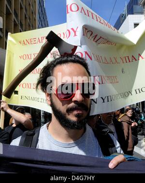 Un uomo con un'ascia mockup sulla sua testa porta un banner nel corso di una protesta da parte di dipendenti del museo del Ministero della Cultura in Atene, Grecia, 13 marzo 2013. Membro dei musei e siti archeologici saranno chiuse fino al 19 marzo 2013 a causa di scioperi dei dipendenti del museo. Le proteste sono rivolte contro la ristrutturazione della politica culturale dell'amministrazione. Foto: Michael Anhaeuser Foto Stock