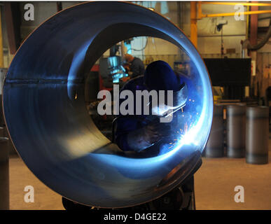 Un saldatore di opere su un grande tubo di metallo al contenitore Huch produttore in Werder, Germania, 11 marzo 2013. Huch costruisce Contenitori per immagazzinamento di calore. La società impiega 140 personale con uffici negli Stati Uniti e Cina. Foto: Bernd Settnik Foto Stock